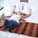 Happy woman falling backwards on hotel bed